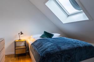 a bedroom with a bed and a skylight at Northstay - City Square in Tromsø