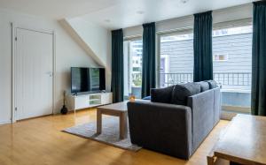 a living room with a couch and a television at Northstay - City Square in Tromsø