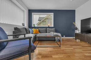 a living room with a couch and a tv at Northstay - The Urban City Haven in Tromsø