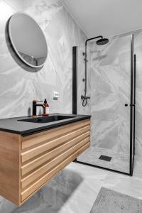 a bathroom with a sink and a shower with a mirror at Northstay - The Urban City Haven in Tromsø