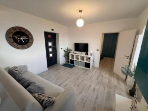 a living room with a couch and a clock on the wall at LOV - Lombadinha Ocean View in Gaula