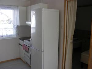frigorifero bianco in cucina con finestra di Nydelig leilighet i første etage. a Sund Altre 2 foto