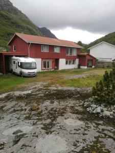 un camper parcheggiato di fronte a una casa rossa. di Nydelig leilighet i første etage. a Sund