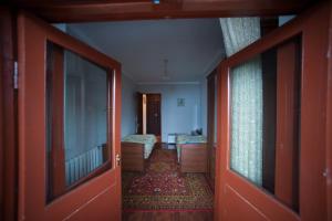 a hallway with a room with two beds and an open door at Baykalsky Pokoy Apartment in Listvyanka