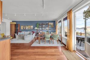 une cuisine et un salon avec une table et des chaises dans l'établissement Cosy top-floor apartment, à Tomasjorda