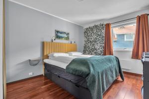 une chambre avec un grand lit et une fenêtre dans l'établissement Cosy top-floor apartment, à Tomasjorda