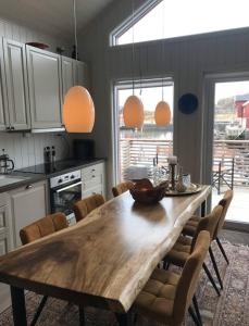 a kitchen with a wooden table and chairs at Amazing waterfront rorbu (free car-charging) in Stamsund