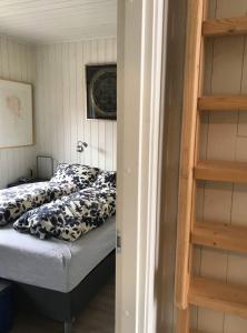 a bedroom with a bed with a black and white comforter at Amazing waterfront rorbu (free car-charging) in Stamsund