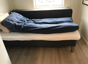 a bed with a blue comforter on top of it at Amazing waterfront rorbu (free car-charging) in Stamsund