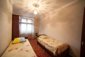 a room with two beds and a window in it at Baykalsky Pokoy Apartment in Listvyanka