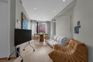 a living room with a couch and a tv at Arctic Escape - Central Design Apartment in Tromsø