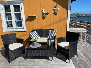 a group of chairs and a table on a porch at Koselig rorbu på Tind in Sørvågen