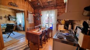 a kitchen and living room with a table and chairs at Koselig rorbu på Tind in Sørvågen