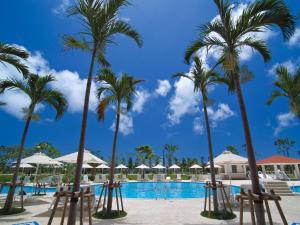 un complejo con palmeras y piscina en Southern Beach Hotel & Resort, en Itoman