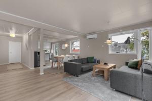a living room with two couches and a table at Northstay - Grimsby House in Tromsø