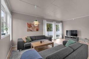 a living room with a couch and a table at Northstay - Grimsby House in Tromsø