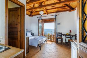 a kitchen and a living room with a view of the ocean at Panorama Skopelos in Stafylos