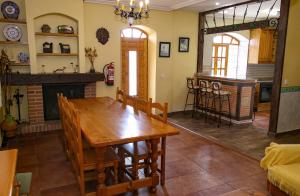 a dining room with a wooden table and a fireplace at La Viña in Huertas de Pedrotello