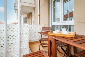 a balcony with a wooden table and chairs at Piso con Piscina in Santander