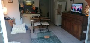a living room with a couch a table and a tv at Appartement cosy à Saint-Mamet - 36 m² - Vue montagne in Saint-Mamet