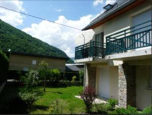 a house with a balcony on the side of it at Appartement cosy à Saint-Mamet - 36 m² - Vue montagne in Saint-Mamet