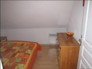 a bedroom with a bed and a wooden table at Appartement cosy à Saint-Mamet - 36 m² - Vue montagne in Saint-Mamet