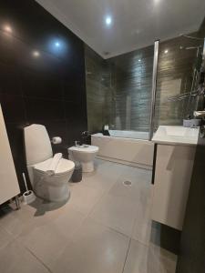 a bathroom with a toilet and a tub and a sink at AL Manas Pereira in Castro Marim +28 photos