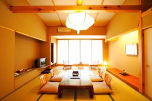 Tsutaya Tokinoyado Kazari في كيسو: غرفة معيشة كبيرة مع طاولة وكراسي