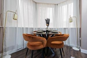 バーミンガムにあるBelgravia Quarters Ltdのテーブルと椅子2脚のあるダイニングルーム