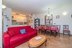 un soggiorno con un divano rosso e un tavolo di Villasoledad appartamenti per vacanze a Capoliveri