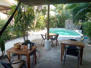 a patio with tables and chairs and a swimming pool at Casa el Colibrí in Parrita +16 photos