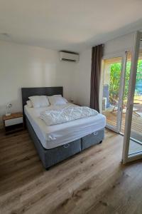 a bedroom with a bed and a sliding glass door at Fiori Di Cala Rossa, Établissement CARDOGA Piscine, Mer & Montagne in Lecci
