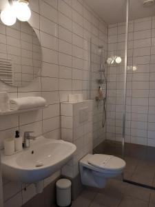 a white bathroom with a sink and a toilet at Charming Retreat Apartment City 20Alpha in Delft