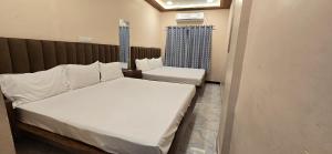 una piccola camera con letto e sedia di Shivnandani a Ujjain Altre 11 foto