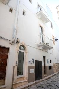- un bâtiment blanc avec une porte et un balcon dans l'établissement I ricami di Annina, à Castellana Grotte