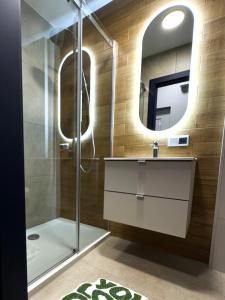 a bathroom with a shower and a sink and a mirror at Apartament w Centrum z widokiem na Stare Miasto Zamość in Zamość