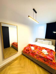 a bedroom with a bed and a large mirror at Apartament w Centrum z widokiem na Stare Miasto Zamość in Zamość