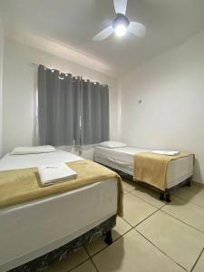 a room with two beds and a ceiling fan at Ap da Thay - Pioneiros in Campina Grande +3 photos