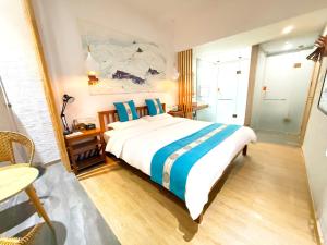 a bedroom with a large bed with blue pillows at Zhangjiajie Forest Park Youth Hostel in Zhangjiajie