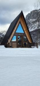 een hut in de sneeuw met een groot raam bij Wooden cottages KONAK in Šavnik