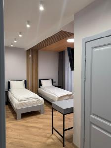 a bedroom with two beds and a table in it at Апарт Злата in Bukovel
