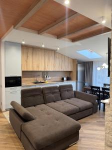 a living room with a brown couch and a kitchen at Апарт Злата in Bukovel +22 photos