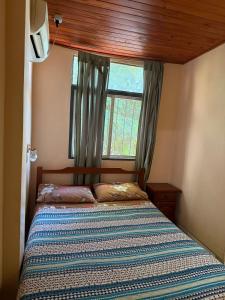 a small bedroom with a bed with a window at Hostel Park Iguazu in Puerto Iguazú +33 photos
