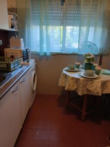a kitchen with a table with plates and flowers on it at Kannon 1 in Caparica