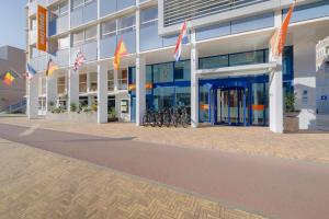 een groot gebouw met vlaggen ervoor bij easyHotel The Hague Scheveningen Beach in Scheveningen +37 foto's