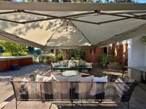 a patio with a table and chairs under an umbrella at Luxurious Ranch Retreat in Nature - Tepotzotlán in San Miguel Cañadas