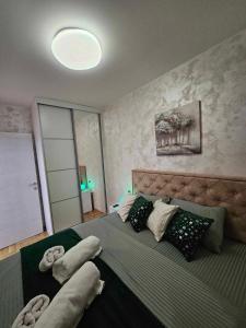 a bedroom with a large bed with pillows on it at Daluxst apartman in Vrnjačka Banja