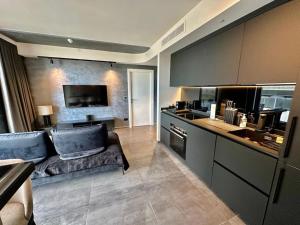 a large kitchen with a couch and a stove at Corner 1 Bed Apart in Mercury Suites with Rooftop Pool Seasonal in St. Julianʼs