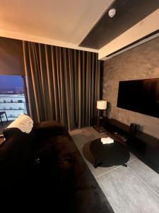 a living room with a couch and a flat screen tv at Corner 1 Bed Apart in Mercury Suites with Rooftop Pool Seasonal in St. Julianʼs