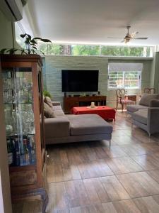 a living room with a couch and a flat screen tv at Casa de Huespedes Guacaras in Santa Ana